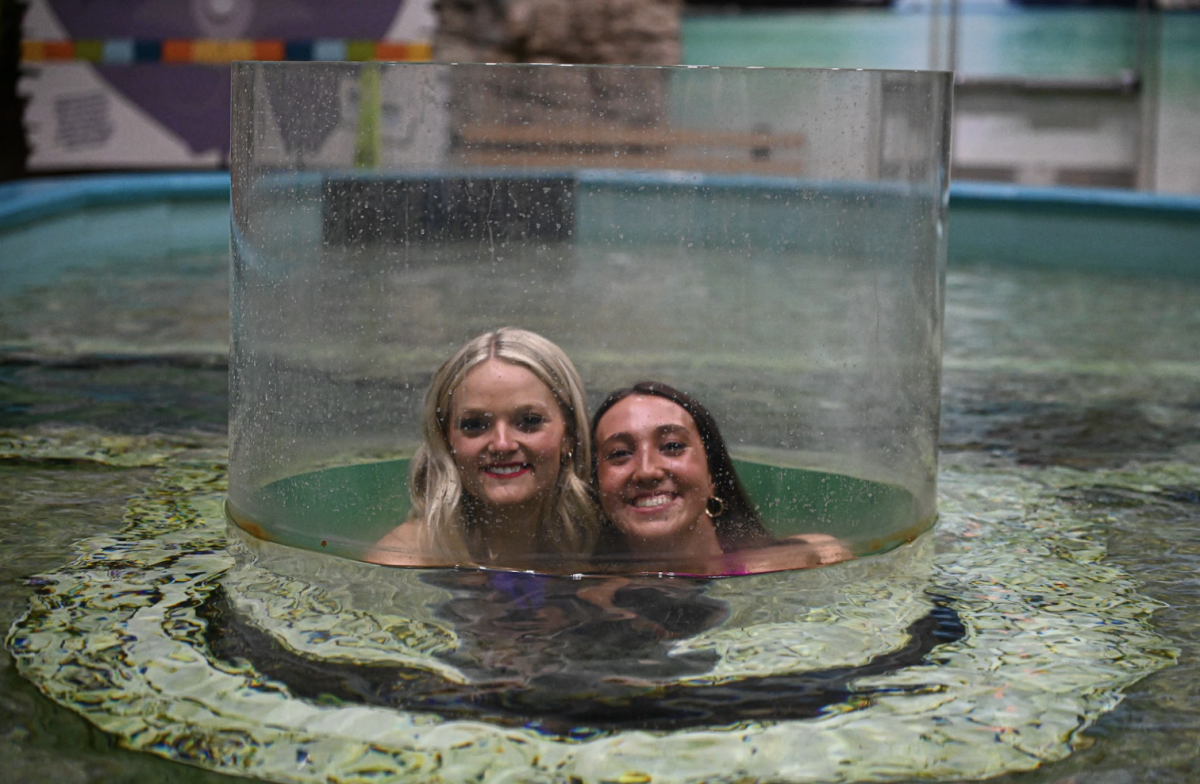 Sydney Schomaker (12) and Lyla Bottom (12) pose for a picture in the stingray tank. 